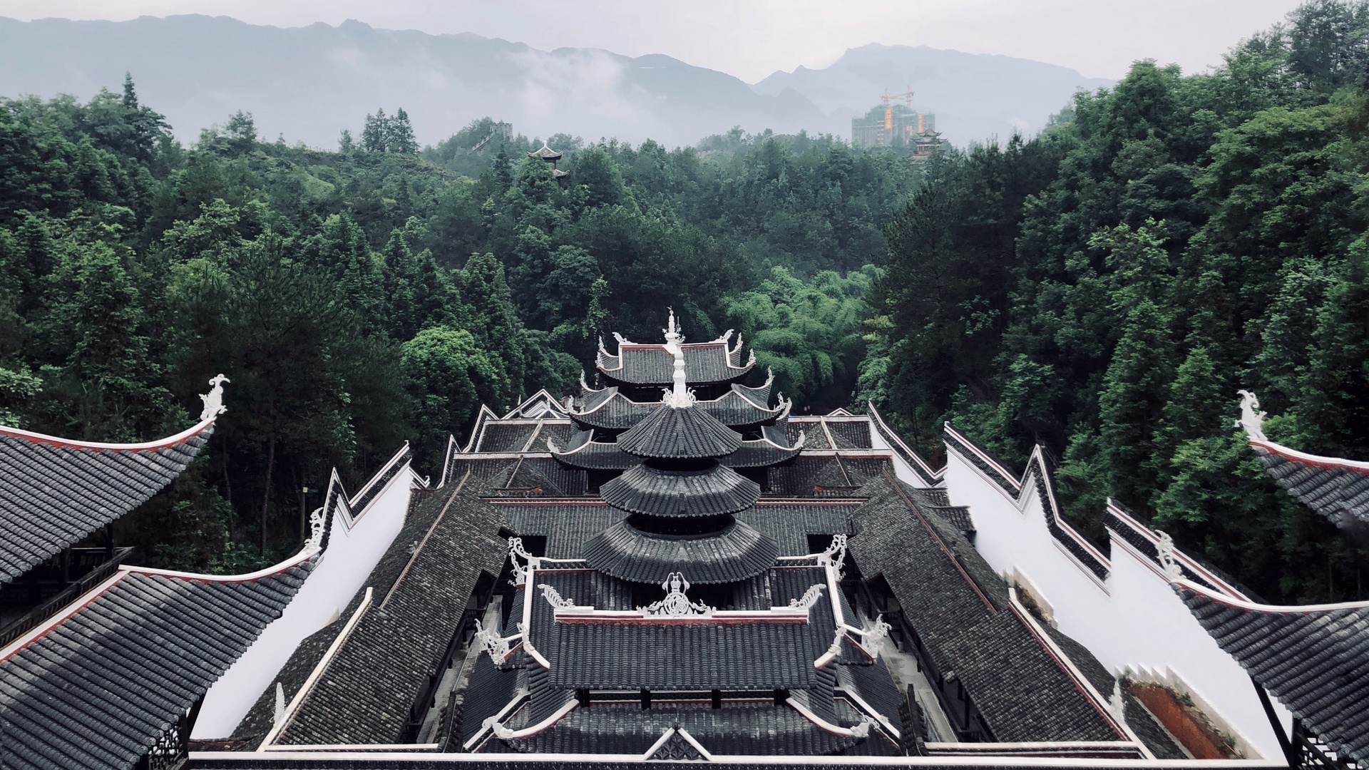 Traditional rooftops surrounded by green hills in Enshi, Hubei